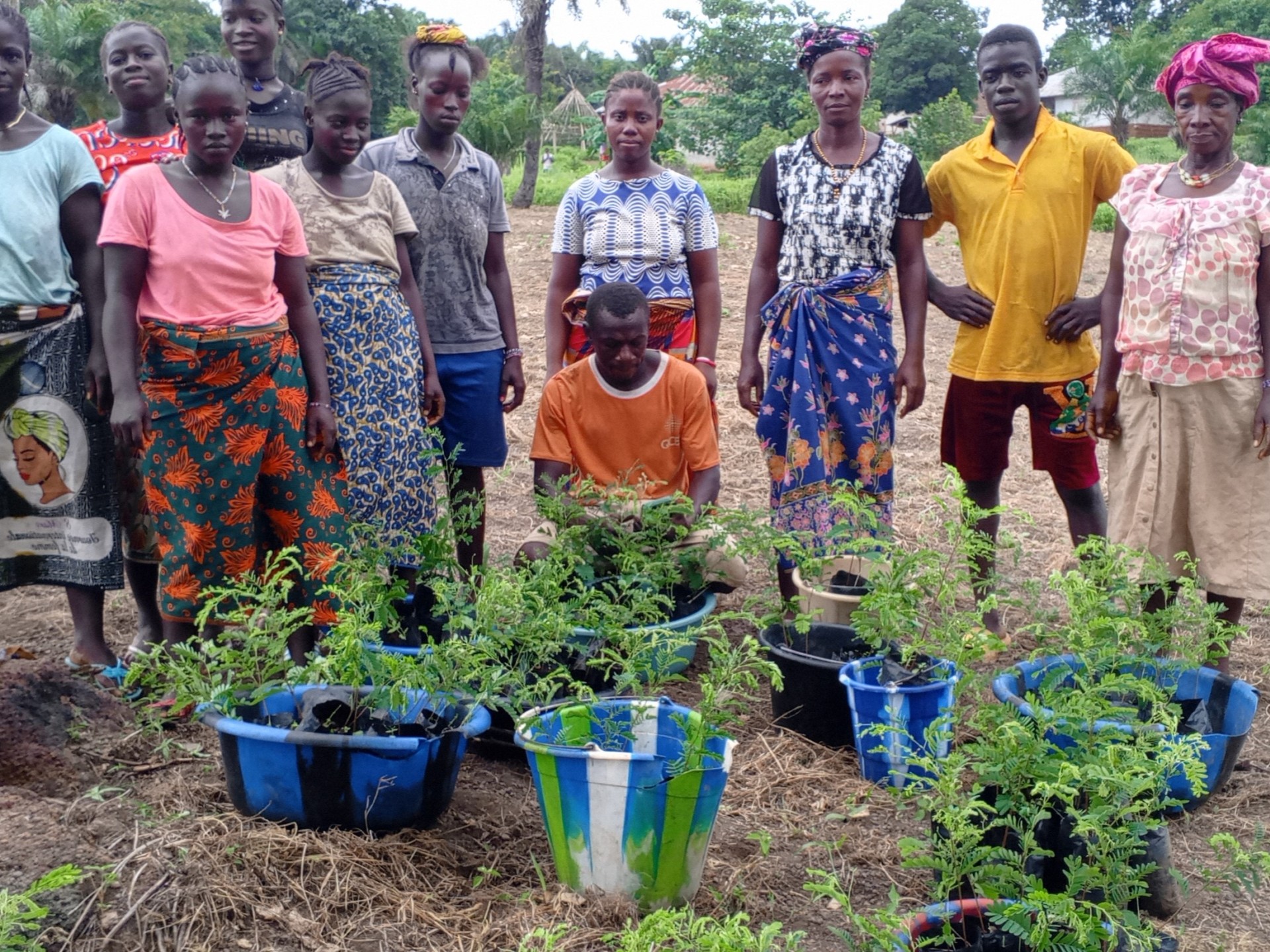 Stolze Bewohner des Impact Villages zeigen die neuen Pflanzen, die sie einpflanzen werden.