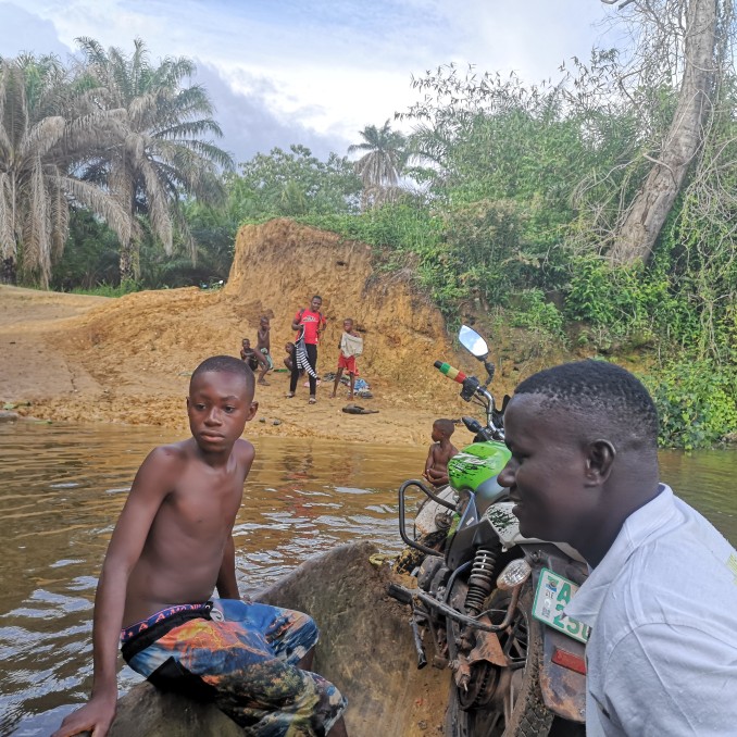 Afrikaner überqueren in einem Boot einen Fluss