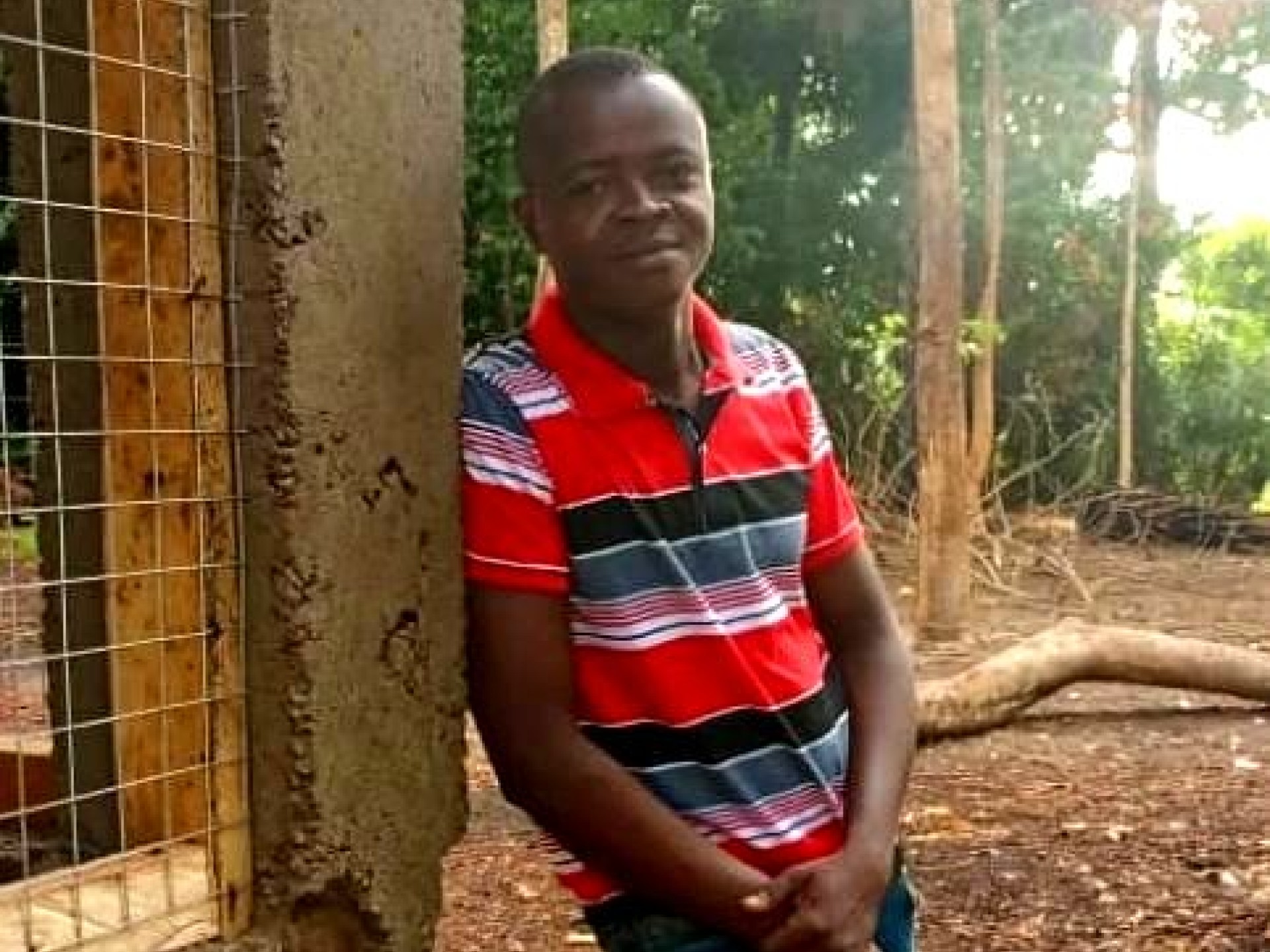 Ein junger afrikanischer Mann steht neben einem Haus