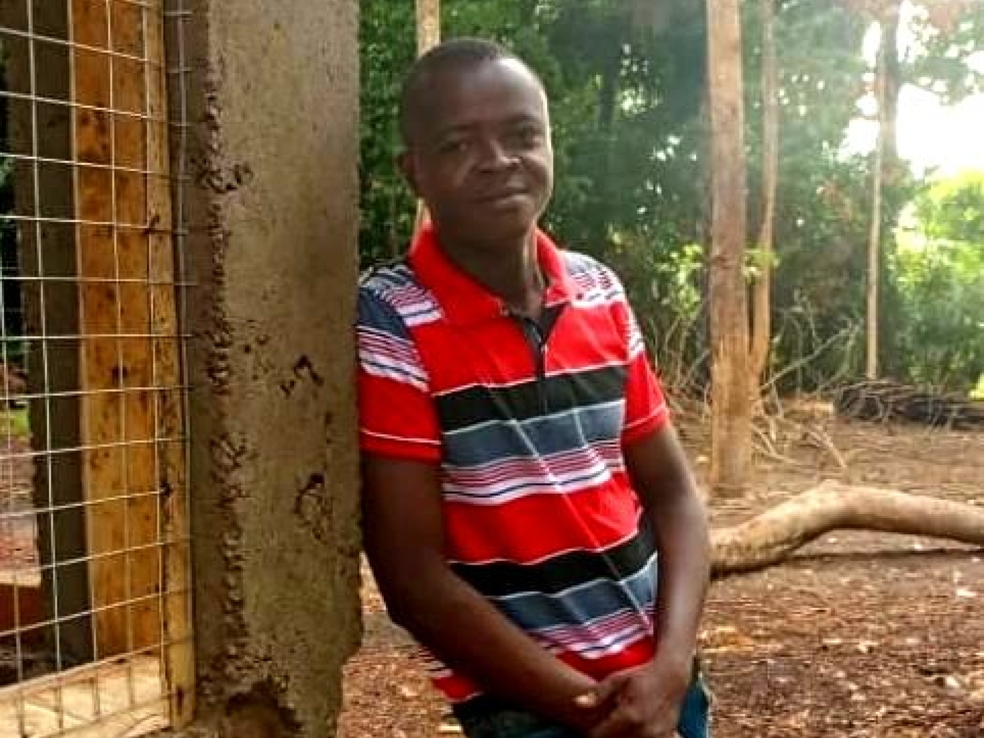 Ein junger afrikanischer Mann steht neben einem Haus