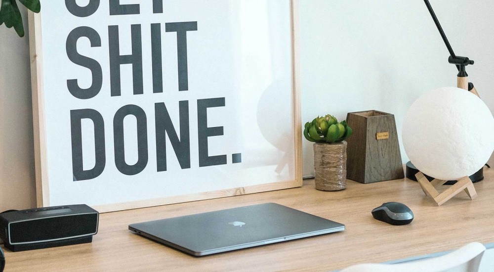 Ein Schreibtischplatz auf dem ein zusammengeklappter Laptop unbd eine Kamera zu sehen sind.