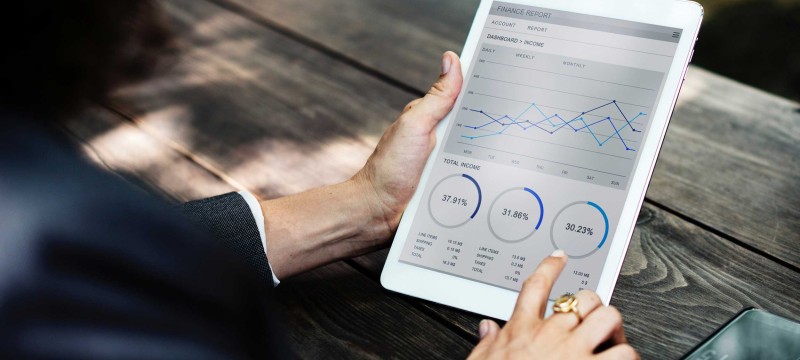 Frau schaut sich Statistiken auf dem Tablet an