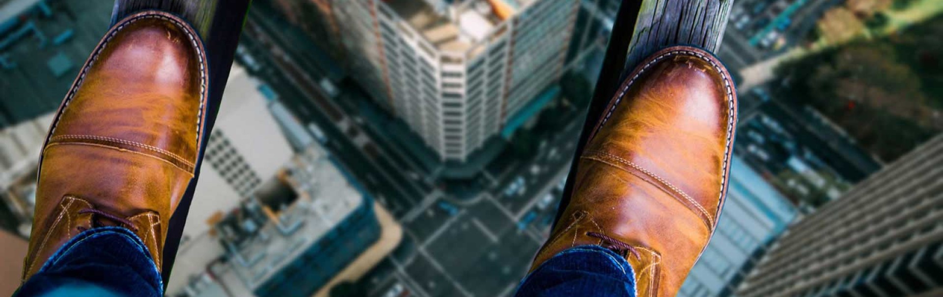 Füße stehen auf zwei Holzbalken in hoher Höhe