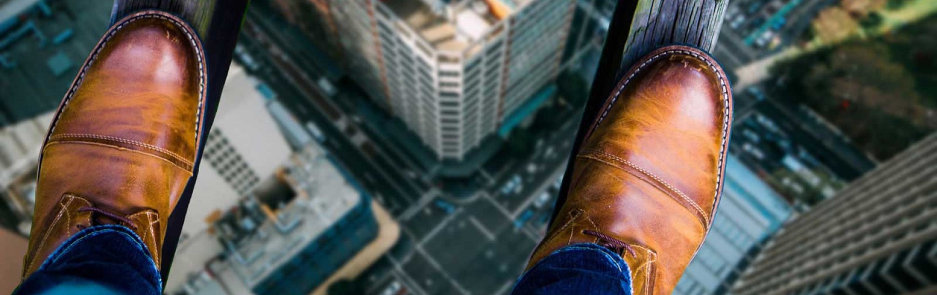 Füße stehen auf zwei Holzbalken in hoher Höhe